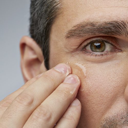 Man putting anti wrinkle gel around the eyes